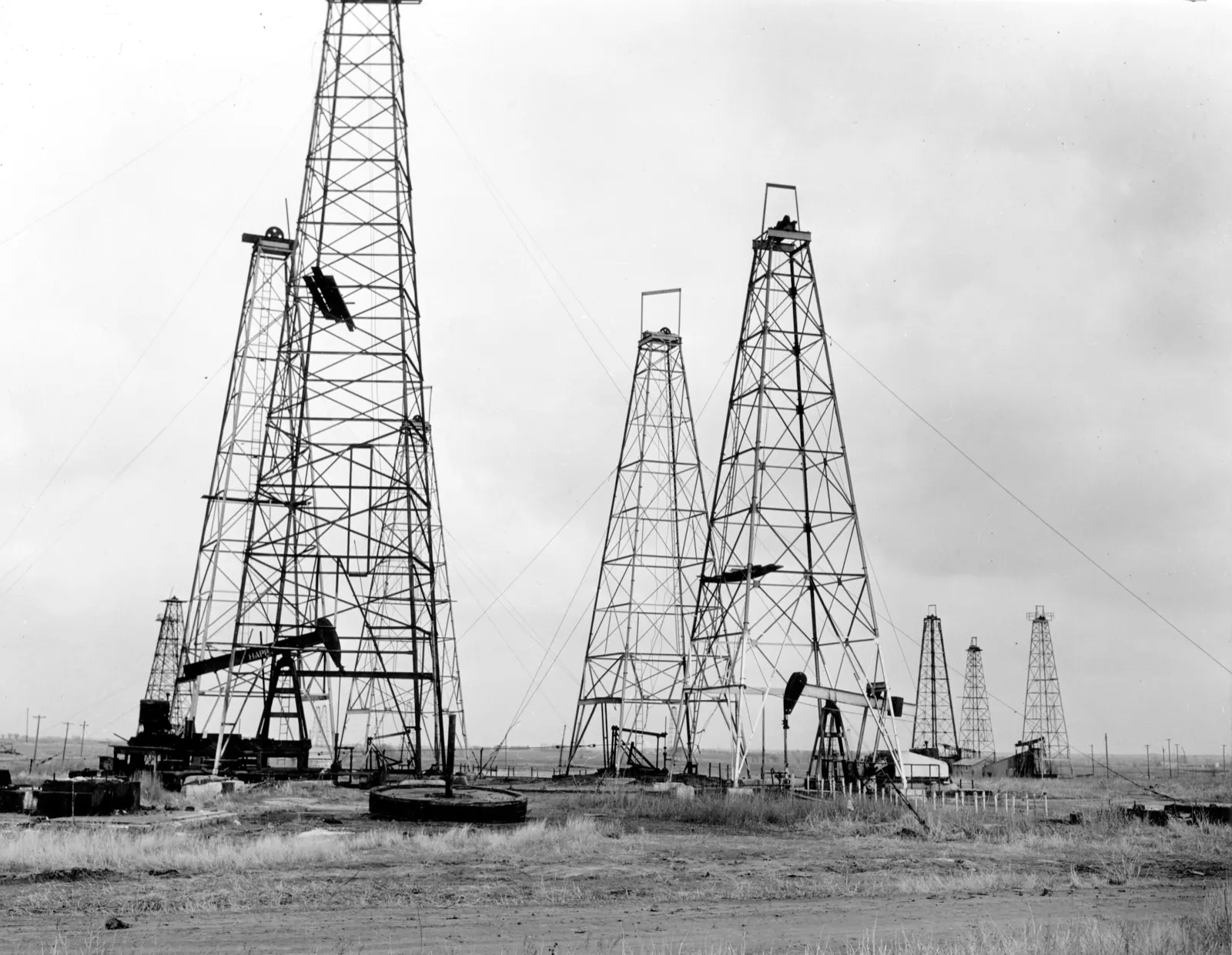 Anadarko Basin in Oklahoma: closely spaced wooden oil derricks and pumping rigs near Pawnee, Oklahoma, in the early twentieth century